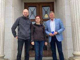 Daniel Golze, Diana Golze und Christian Görke stehen vor einer Eingangstür mit Säulen