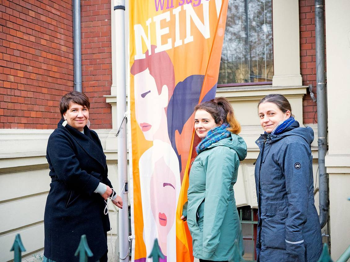 Katharina Slanina, Claudia Sprengel und Julia Wiedemann stehen neben der UN-Women-Flagge, die an einem Fahnenmast besfestigt ist
