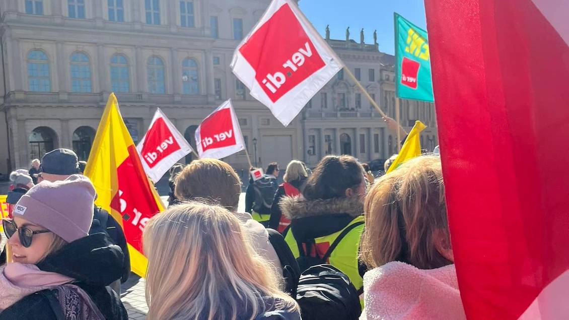 Kundgebung auf dem Alten Markt in Potsdam mit Fahnen, auf denen das ver.di-Logo zu sehen ist